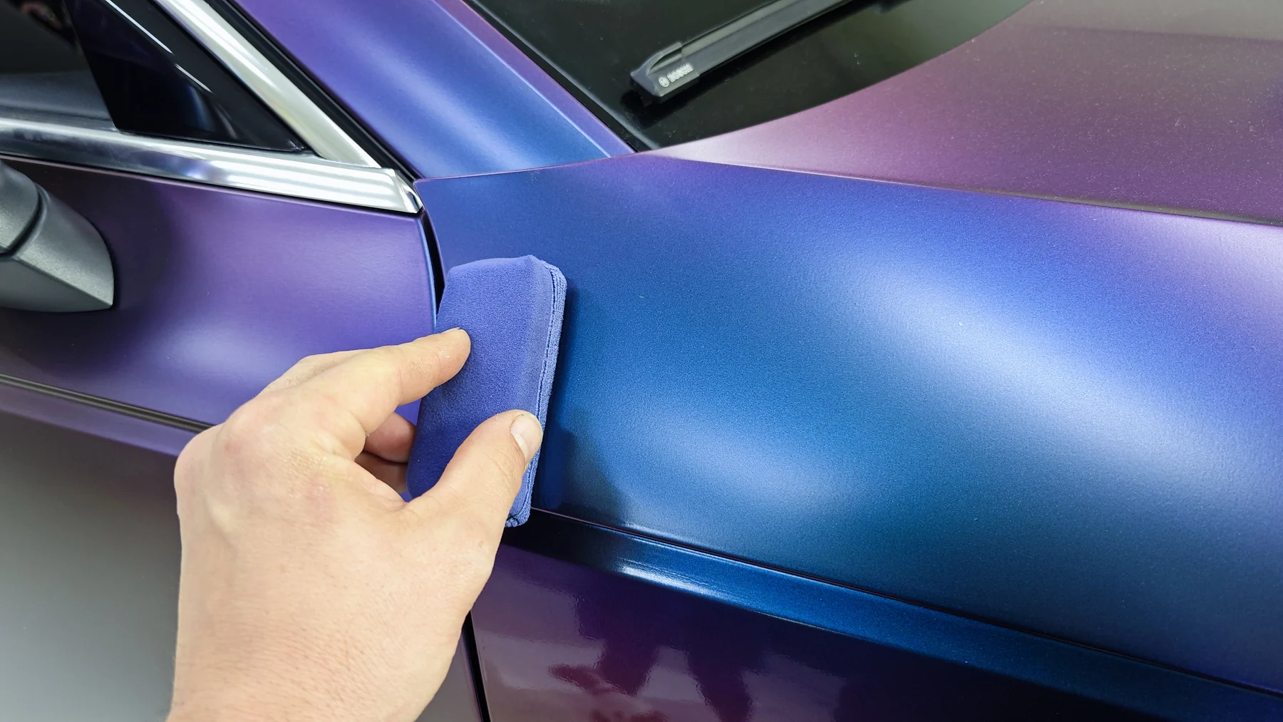 Detail ruční aplikace fólie na karoserii Audi A4