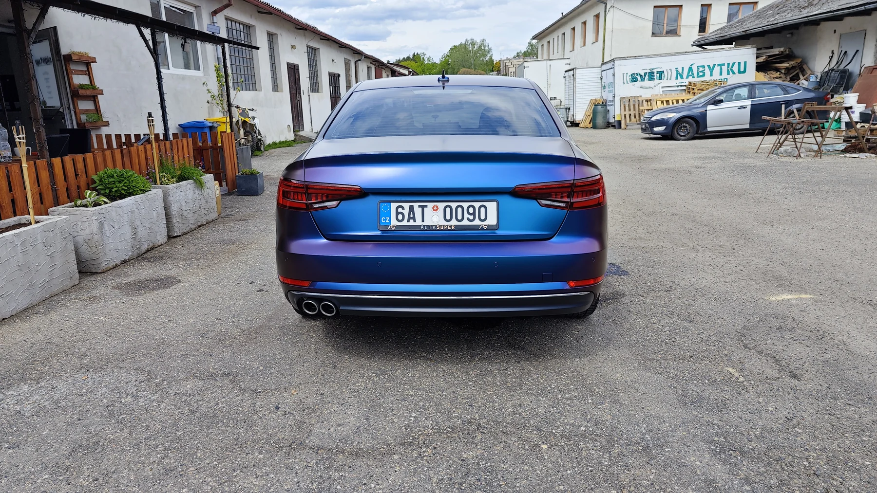 Audi A4 s fialovomodrým polepem při pohledu zezadu