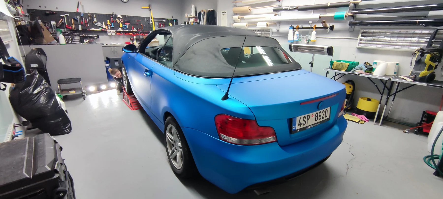 Modře polepený kabriolet BMW zezadu s nataženou tmavou střechou