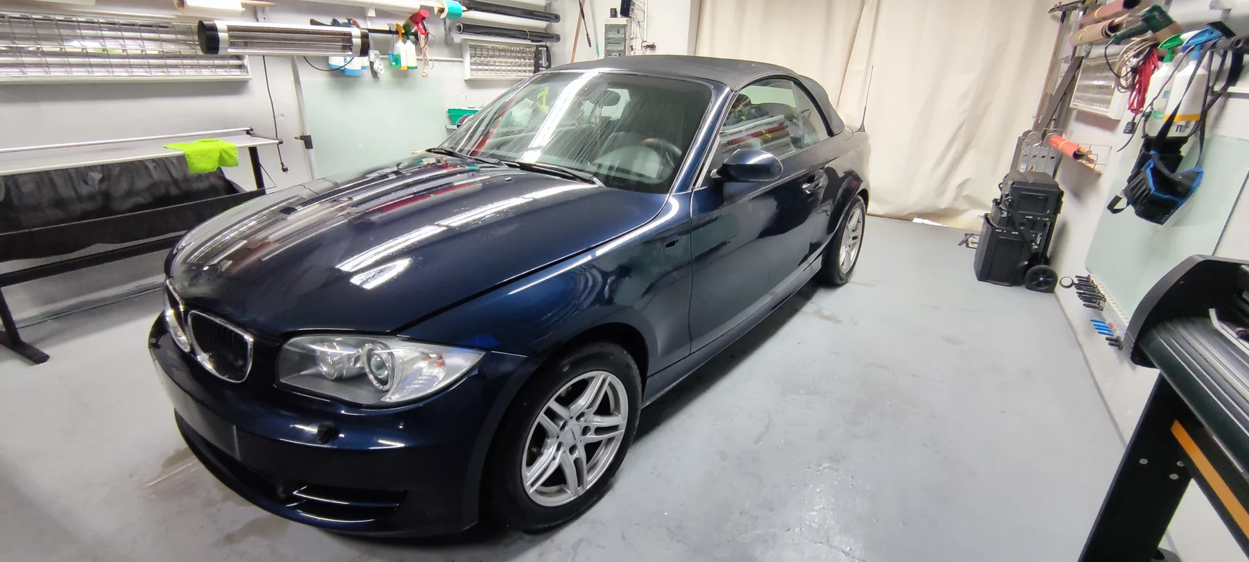 Tmavě modrý kabriolet BMW před barevnou proměnou v dílně