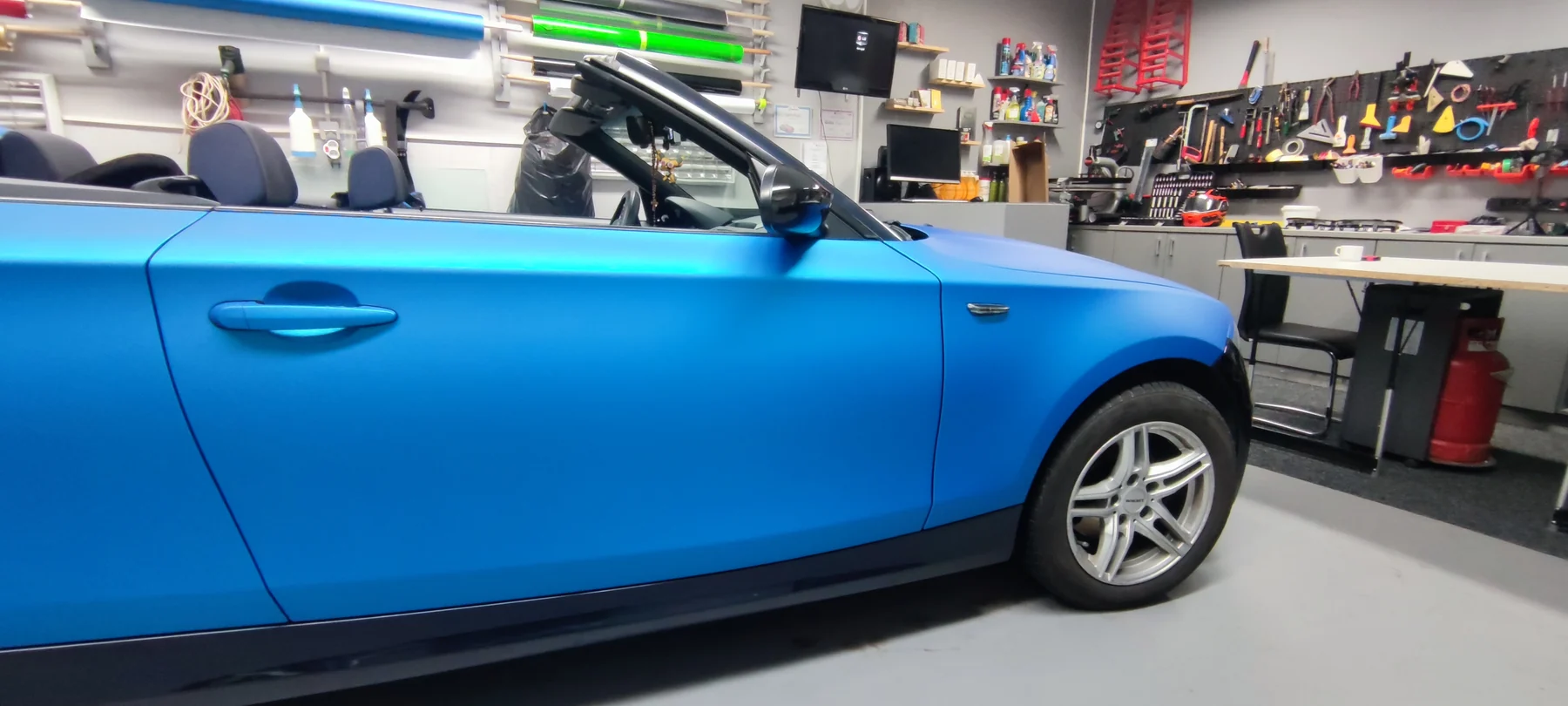 Bok kabrioletu BMW během aplikace modré fólie