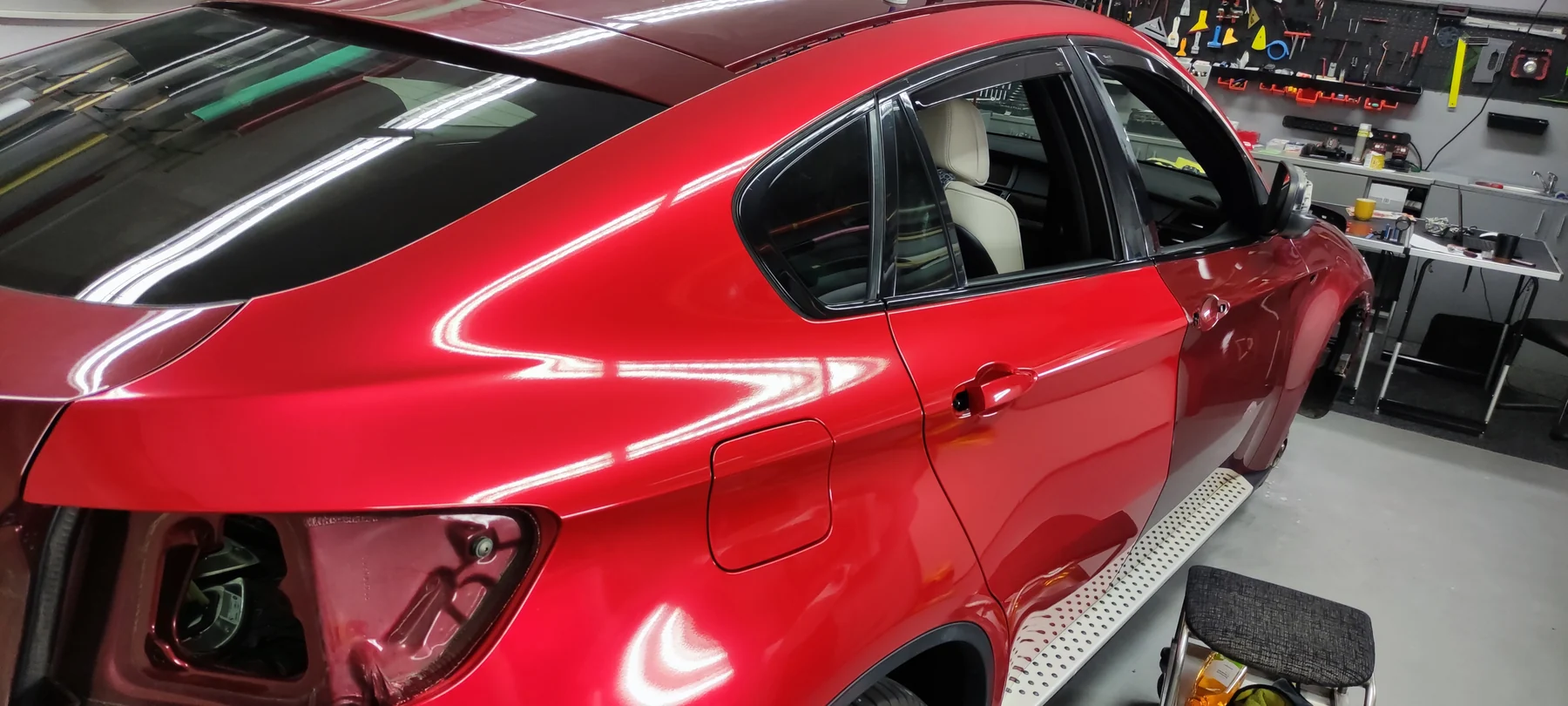 Rozpracované BMW X6 s nově červeným bokem a vyjmutými zadními světly