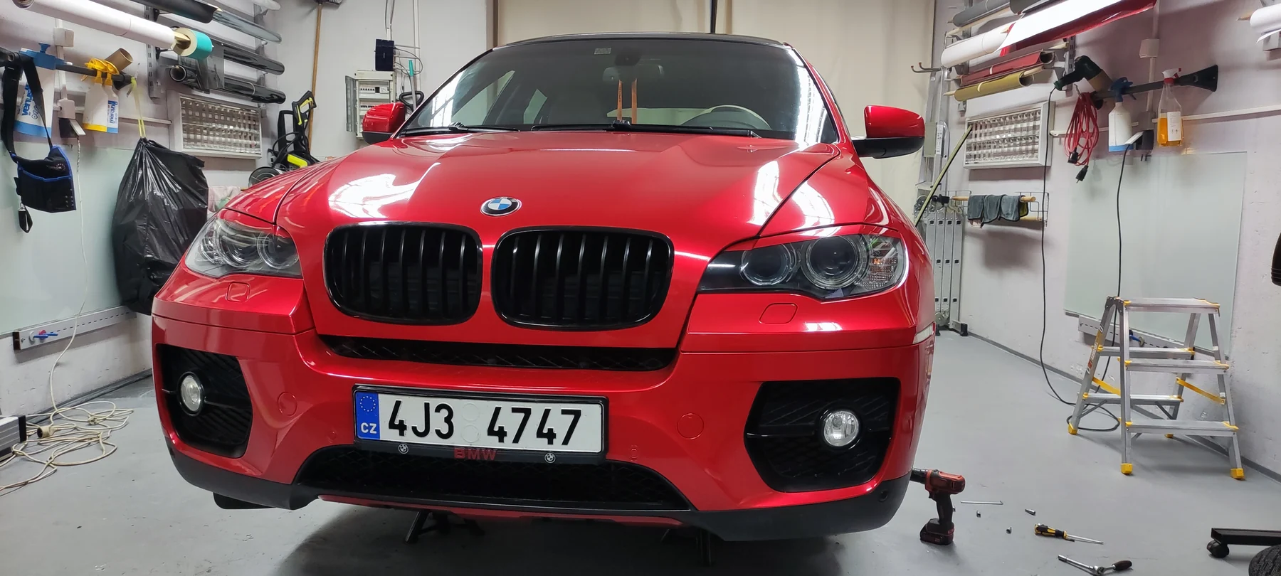Čelní pohled na červené BMW X6 s dokončenými nárazníky a kapotou