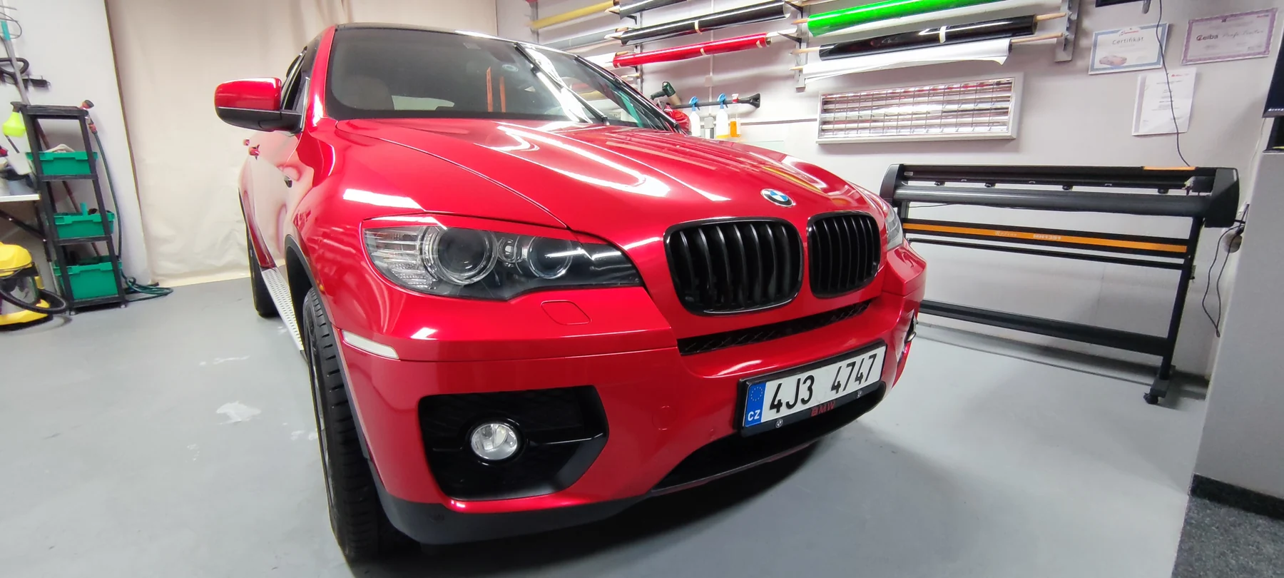 BMW X6 po celopolepu v lesklé syté červené zepředu a z boku
