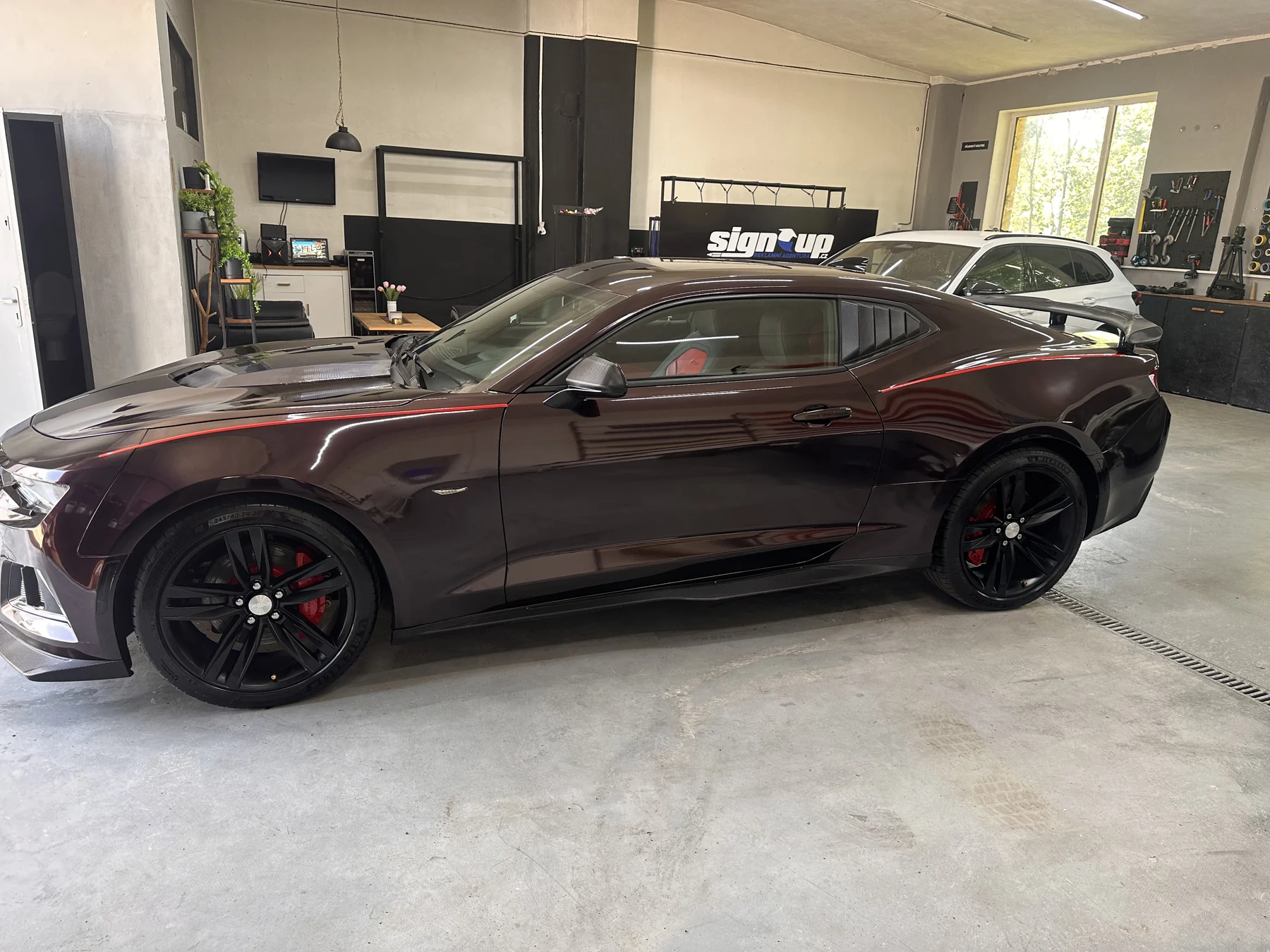 Celý bok Chevroletu Camaro s tmavě fialovým polepem a červenou linkou