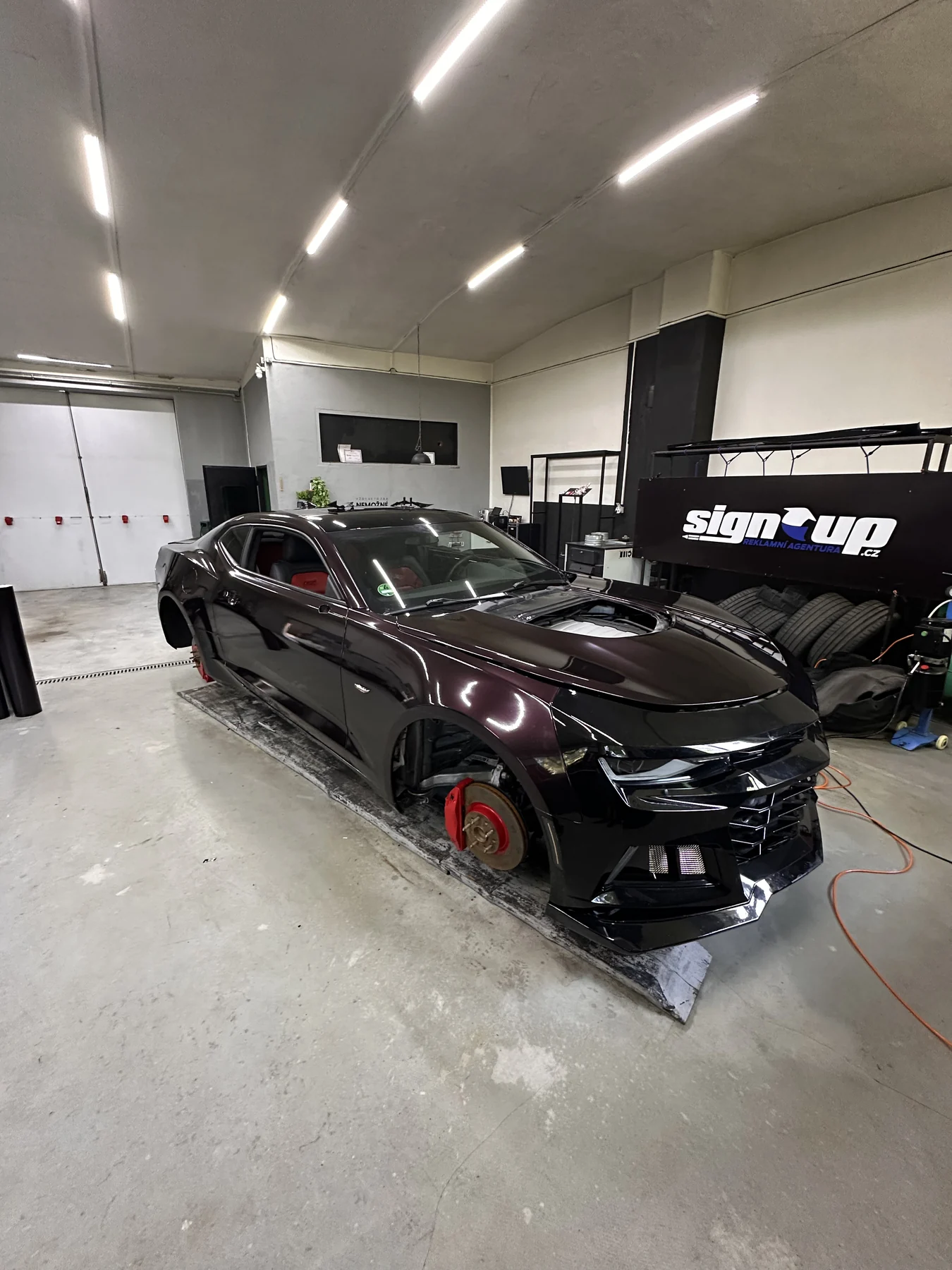 Chevrolet Camaro s fialovým polepem při dokončování v dílně