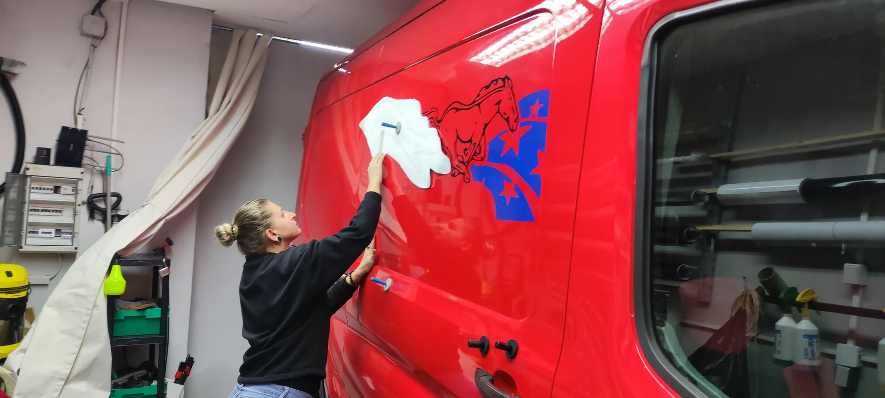 Aplikace bílého a černého motivu koně na červený Ford