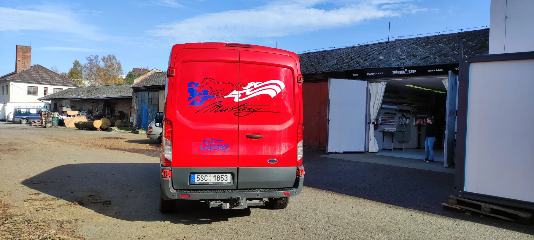 Zadní dveře červené dodávky Ford s opakovaným motivem koně
