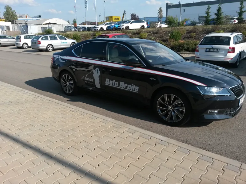 Tmavý Superb Auto Brejla s golfovým motivem zepředu a z boku