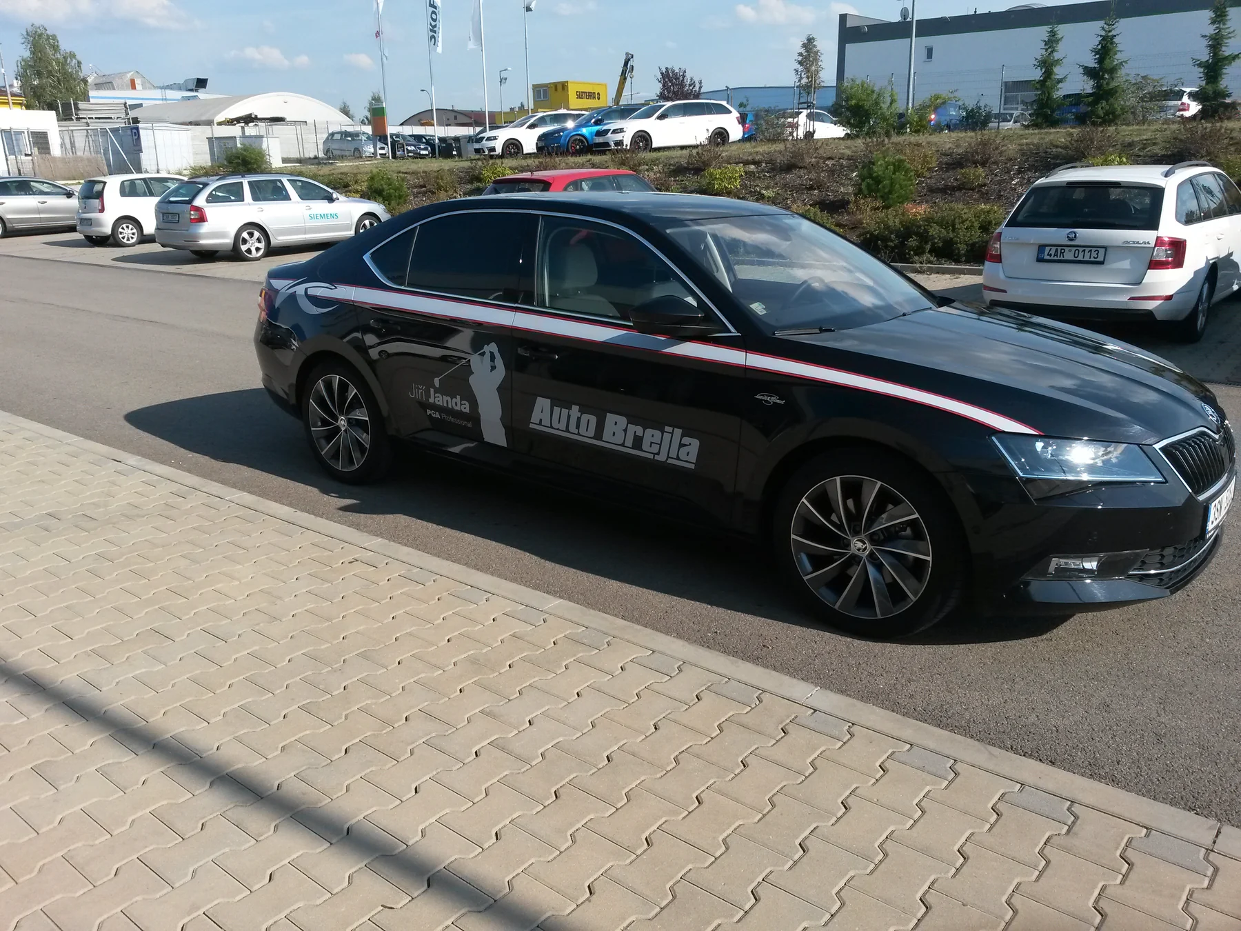 Tmavý Superb Auto Brejla s golfovým motivem zepředu a z boku