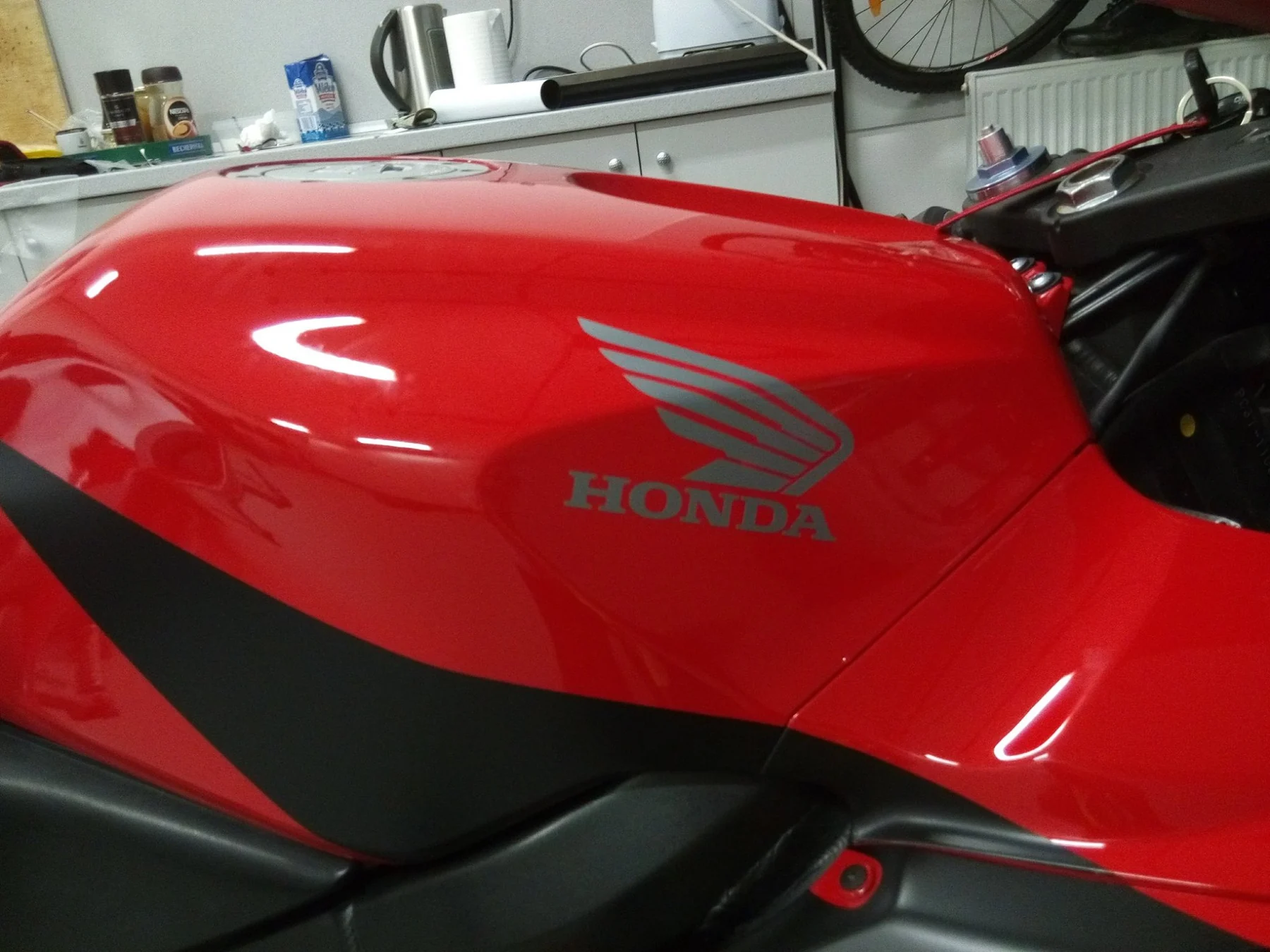 Detail grafiky na nádrži červeného motocyklu Honda