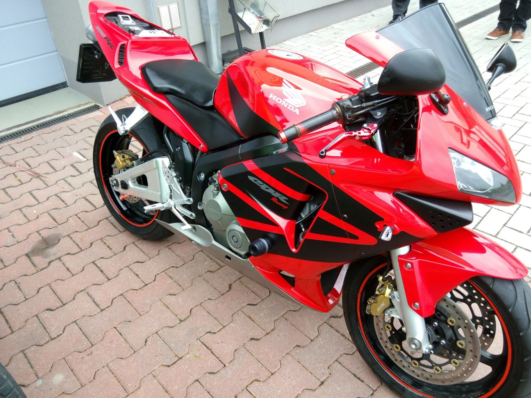 Červená Honda CBR 600RR s černými grafickými prvky zepředu a z boku