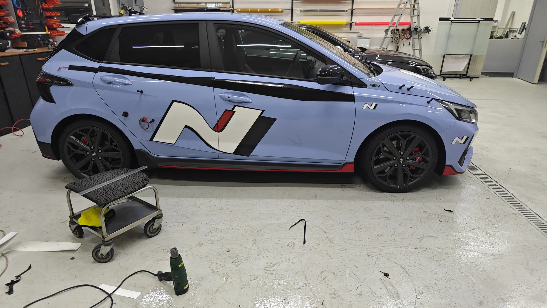Světle modrý Hyundai s velkým bílým znakem N a geometrickými prvky na dveřích