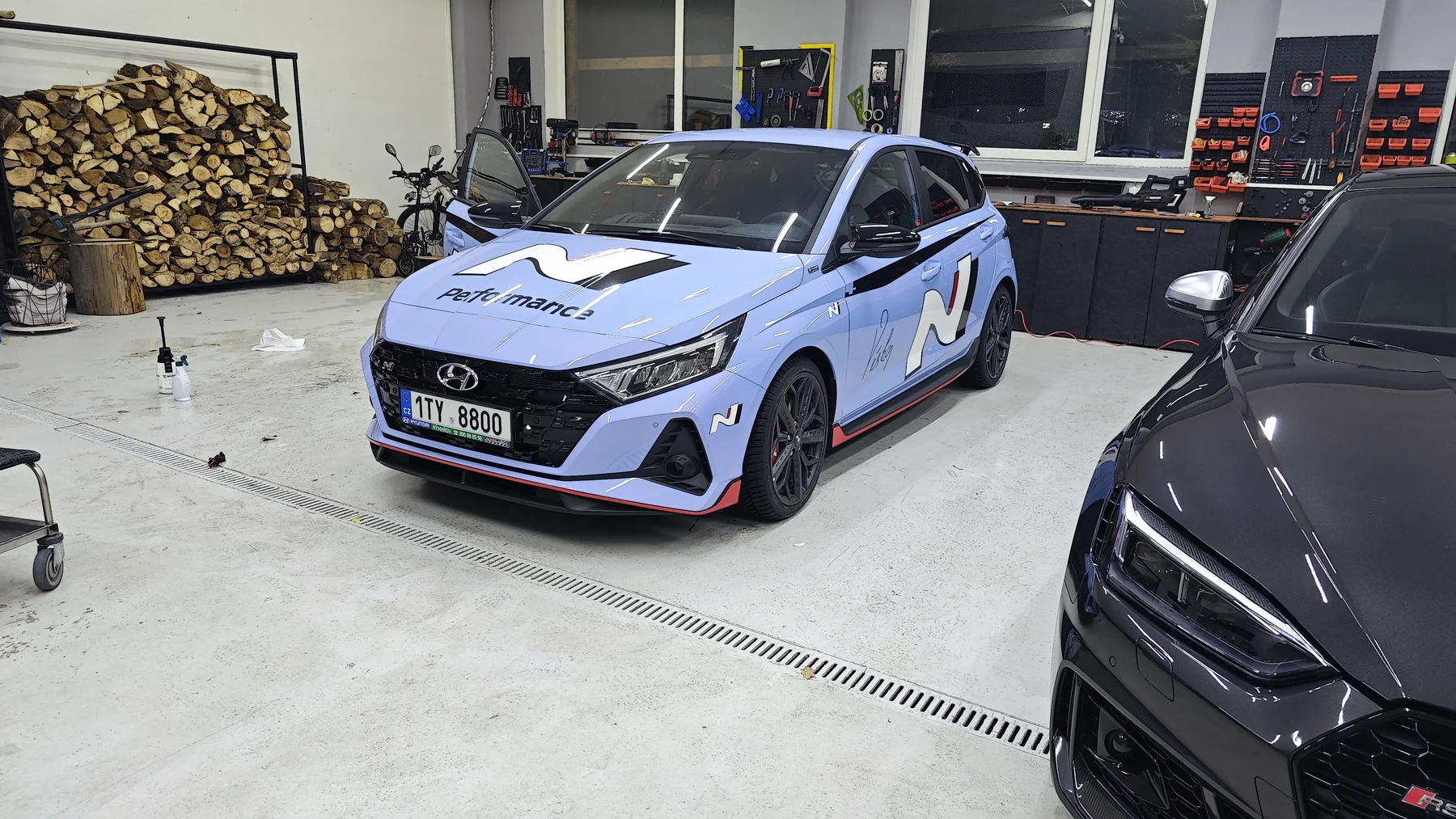 Světle modrý Hyundai i20N s černobílou sportovní grafikou zepředu