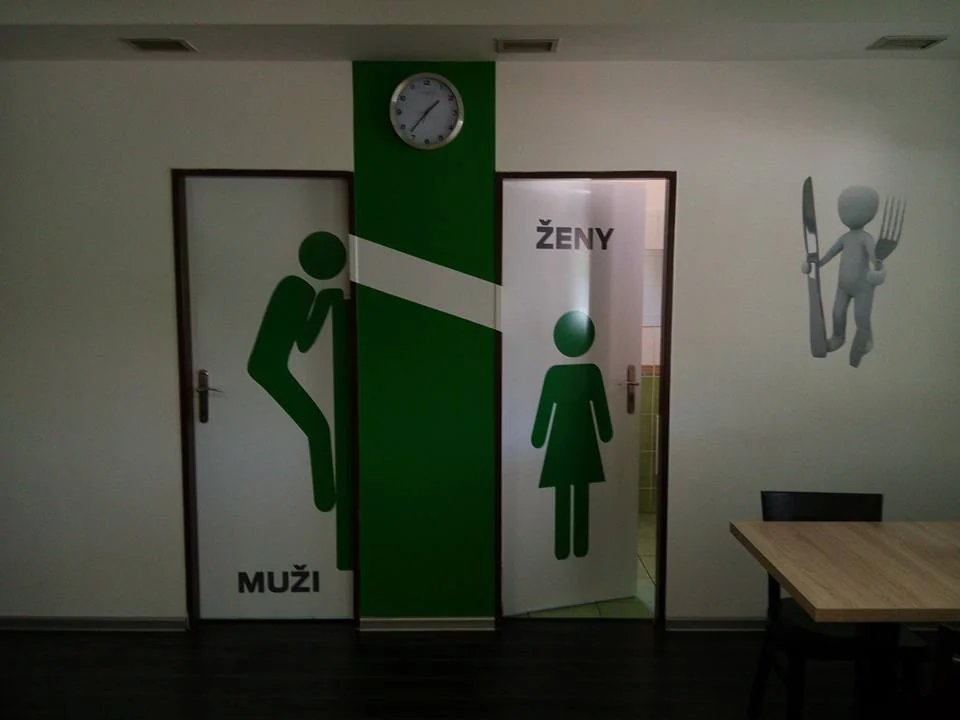 Zelené piktogramy a nápisy Muži a Ženy na dveřích v interiéru