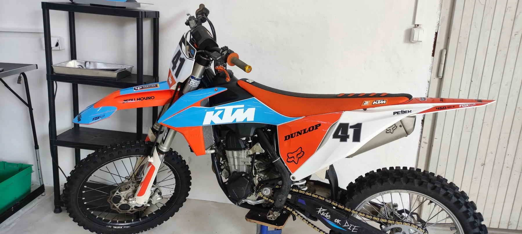 Motokrosová KTM s oranžovou, světle modrou a bílou grafikou a číslem 41