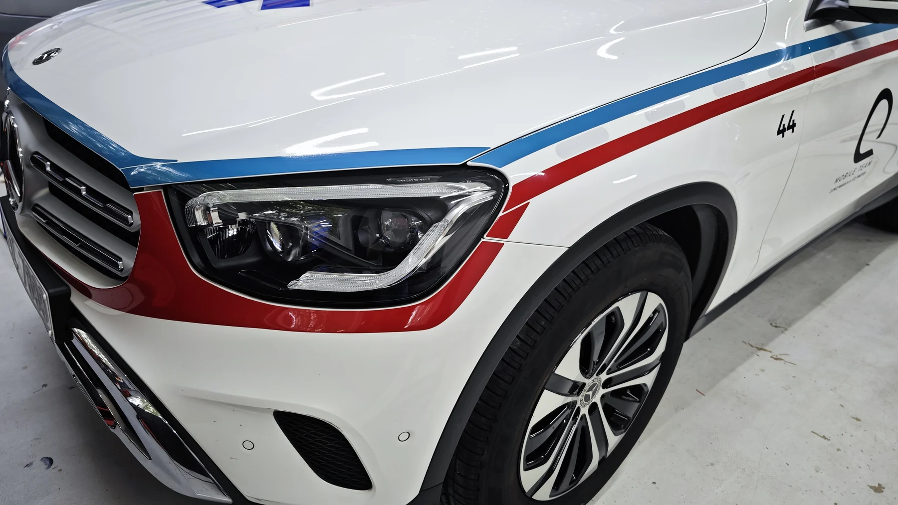 Detail červené linky u předního světla bílého Mercedesu