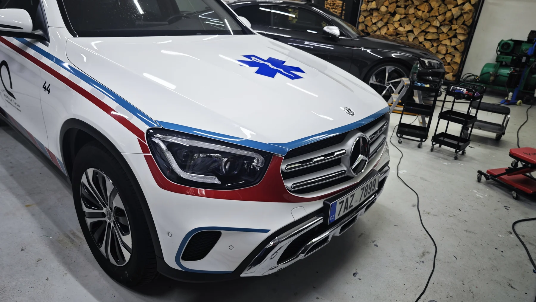 Bílý Mercedes CLINIQ se zdravotnickým polepem zepředu a z boku