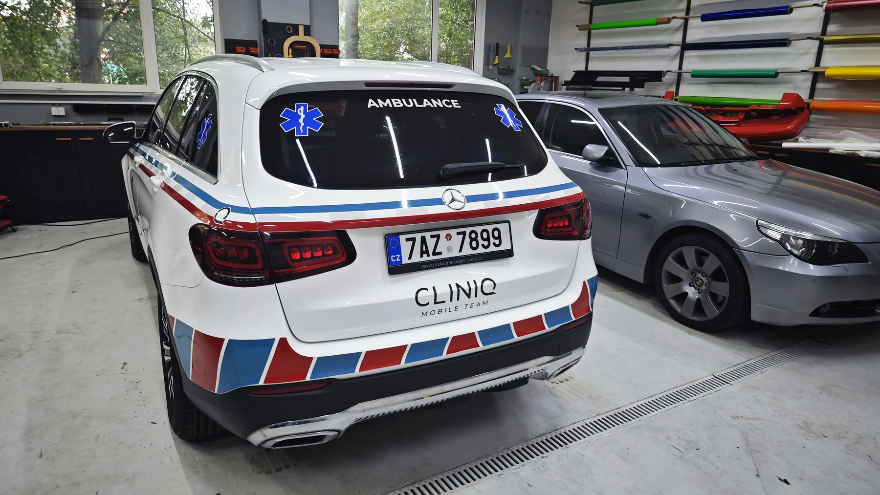 Zadní dveře Mercedesu s nápisem CLINIQ a modrým symbolem