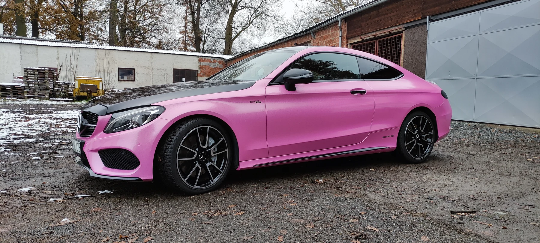 Boční pohled na růžový Mercedes kupé s černou střechou a tmavými koly