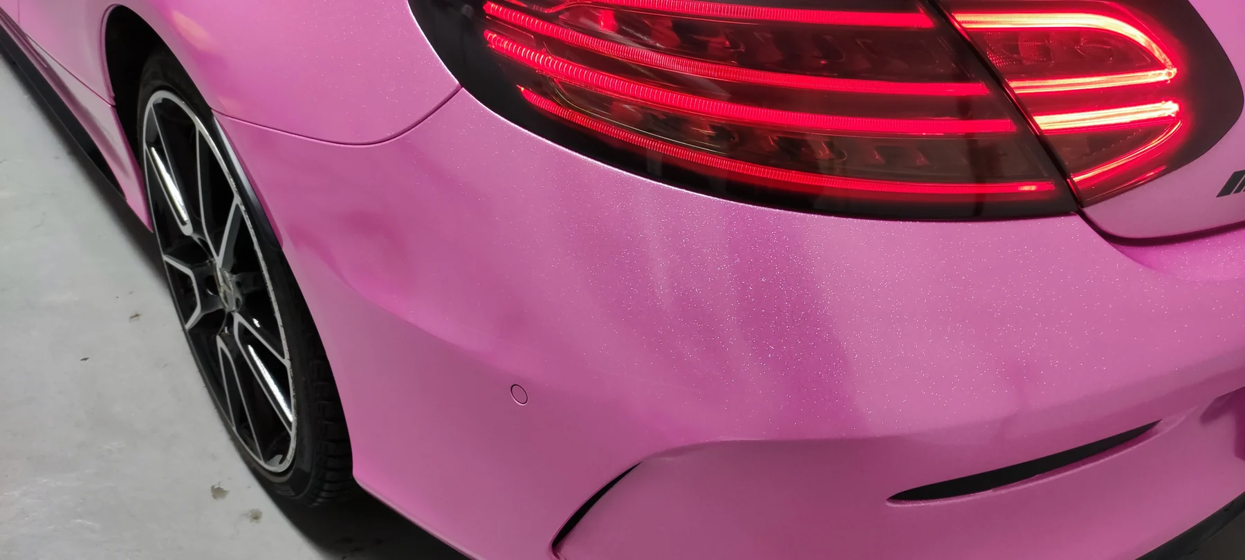 Detail růžového polepu Mercedesu kolem zadního světla a nárazníku