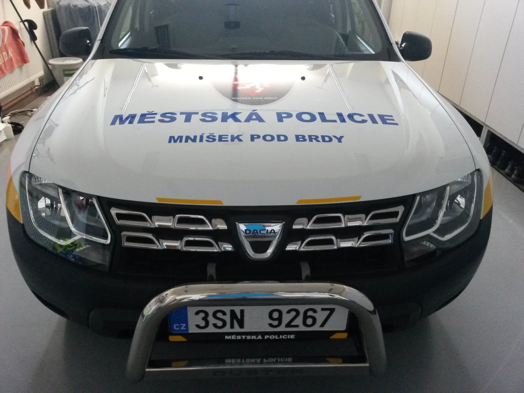 Kapota Dusteru s městským znakem a názvem Městská policie