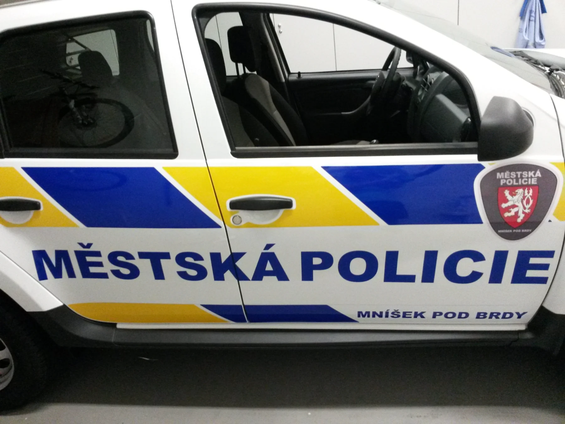 Detail dveří Dusteru s označením Městská policie Mníšek pod Brdy