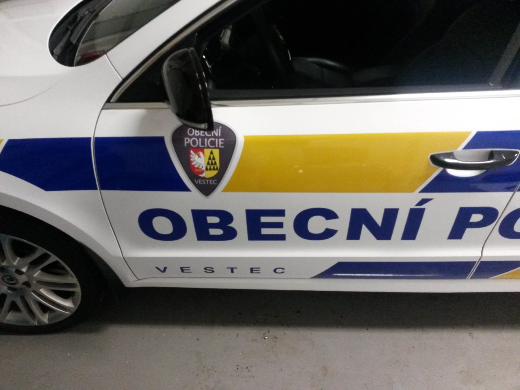 Detail znaku a modrožlutého pruhu na dveřích Superbu policie Vestec