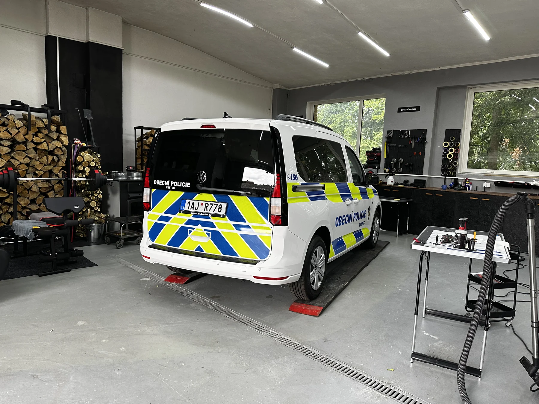 Zadní část Volkswagenu Caddy při dokončování policejního polepu