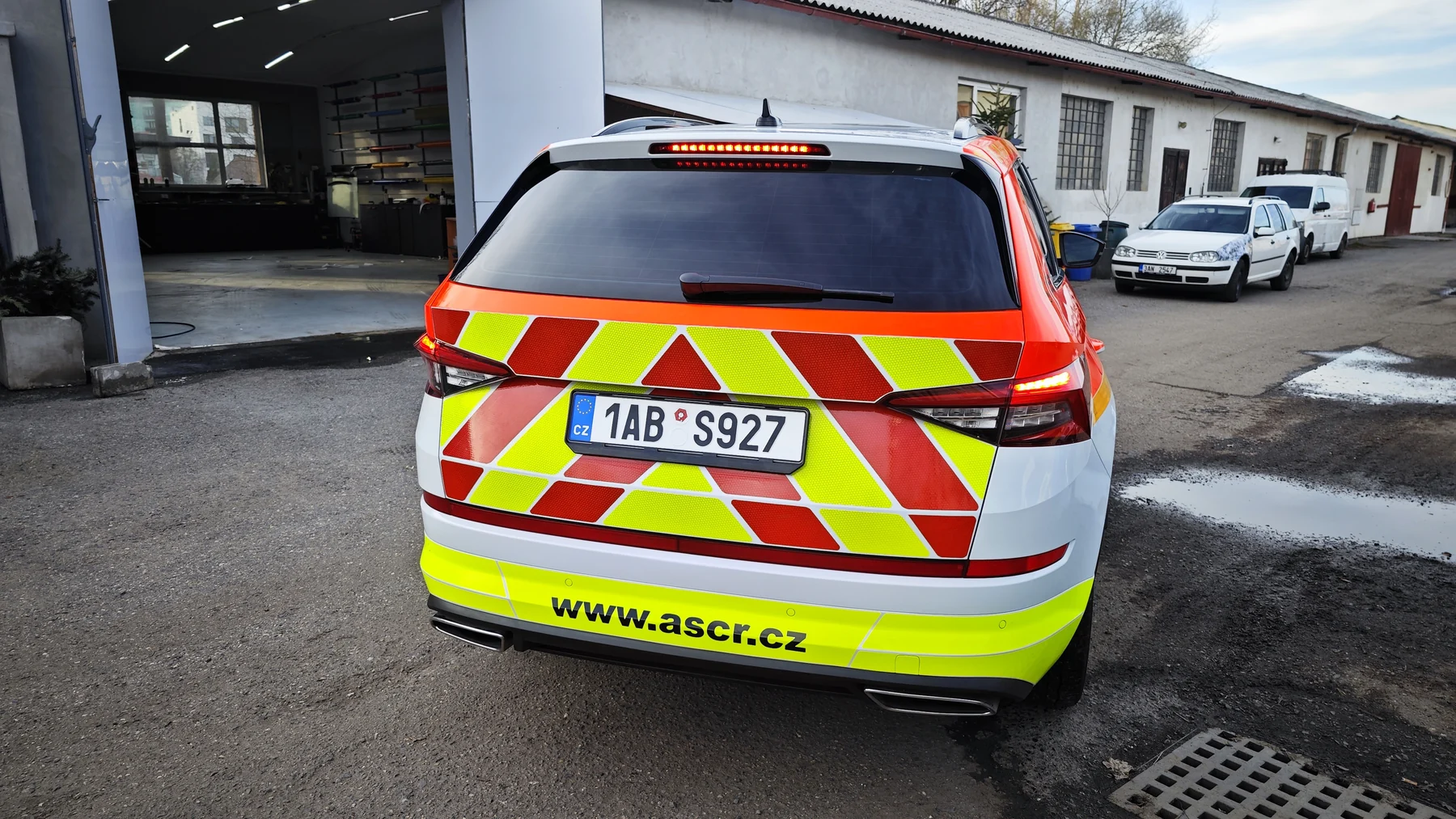 Zadní část záchranářského SUV s červenými a žlutými šikmými pruhy