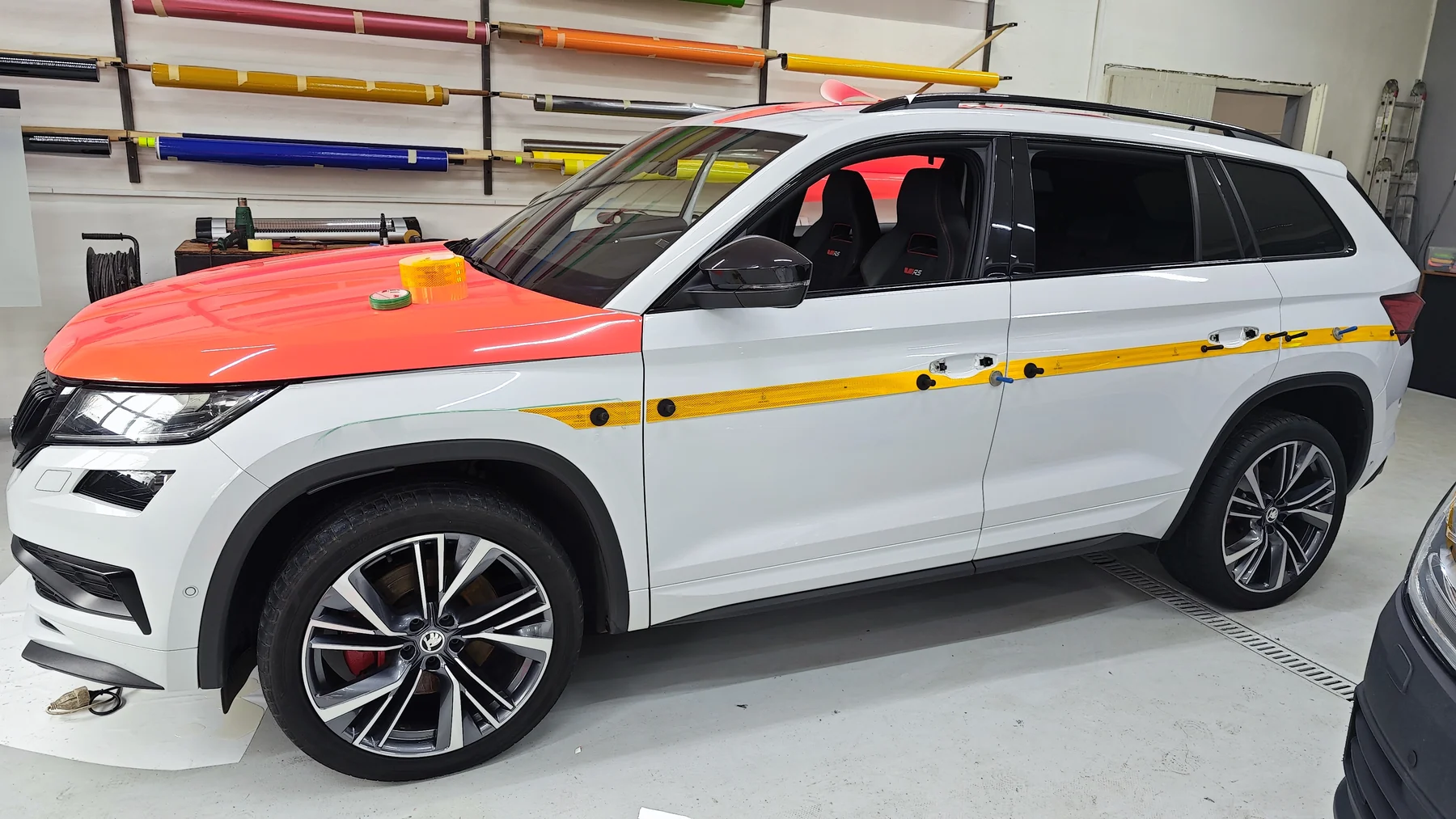 Bílé SUV ASČR během přípravy oranžové části polepu