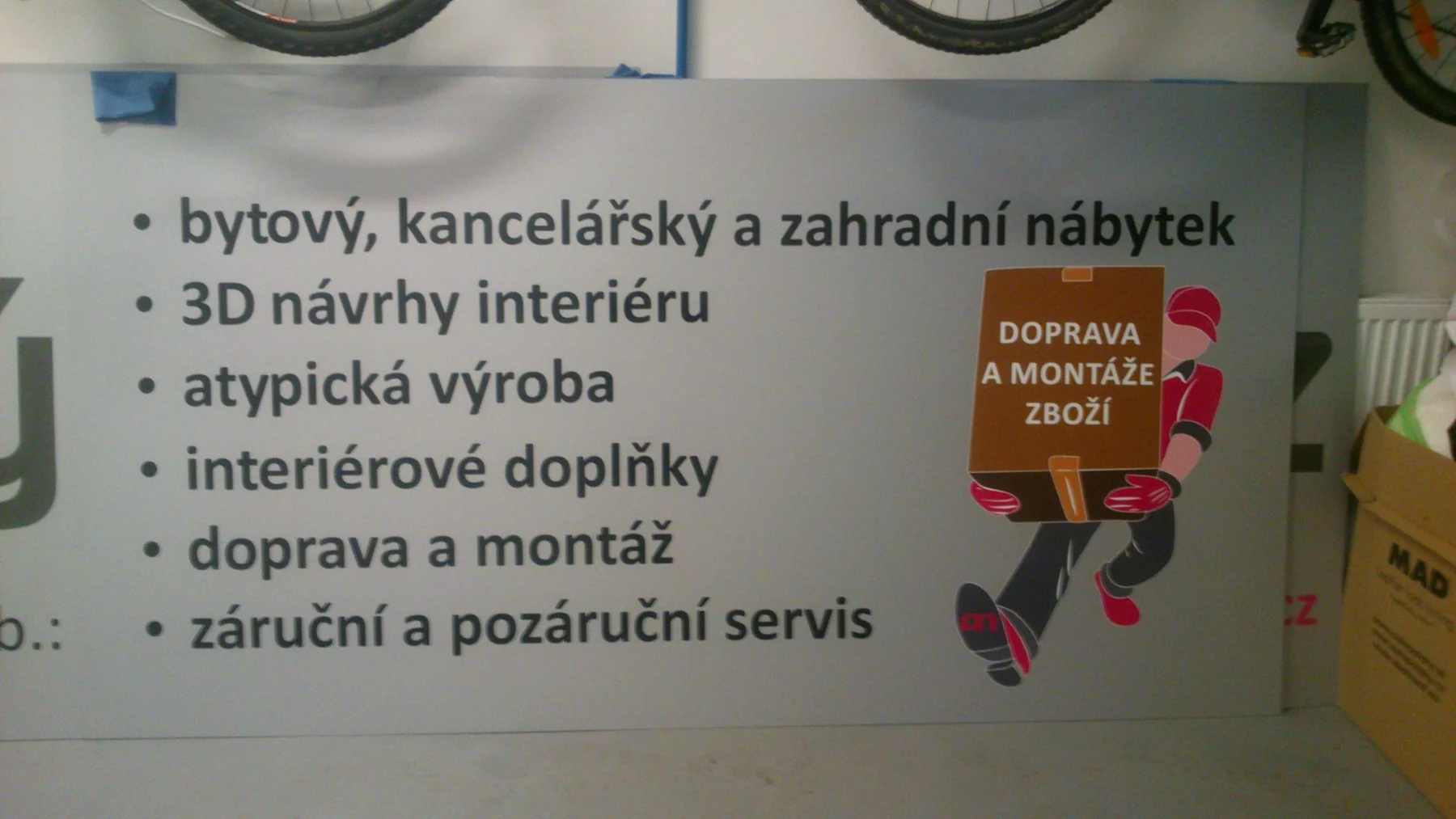 Reklamní panel Pěkný nábytek s přehledem služeb a ilustrací dopravy