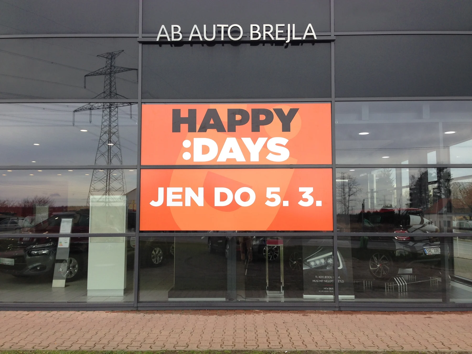 Oranžový polep Happy Days na výloze autosalonu Auto Brejla
