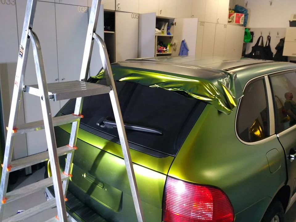 Rozpracovaný polep Porsche Cayenne kolem zadní části střechy v dílně