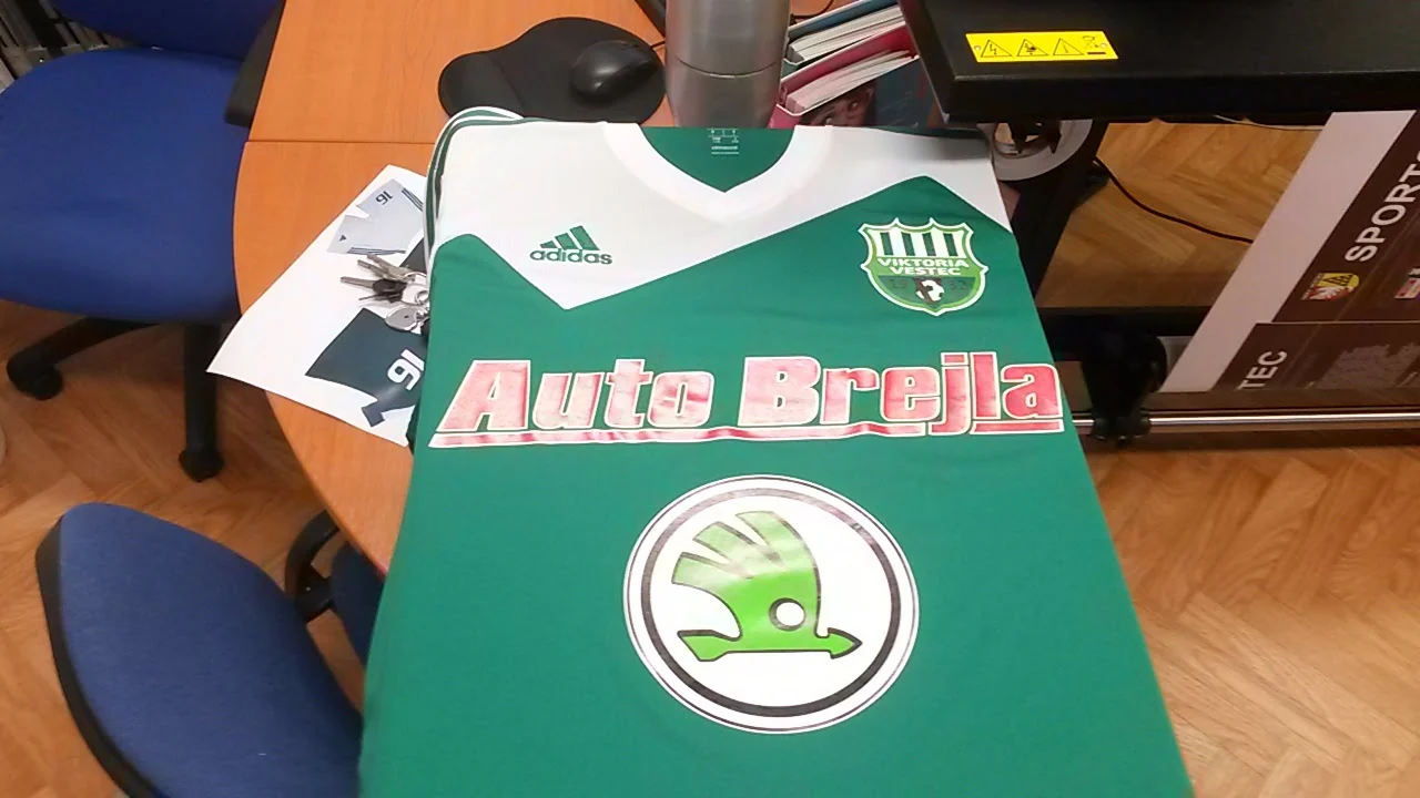 Zelenobílý sportovní dres s logem Auto Brejla a znakem na hrudi