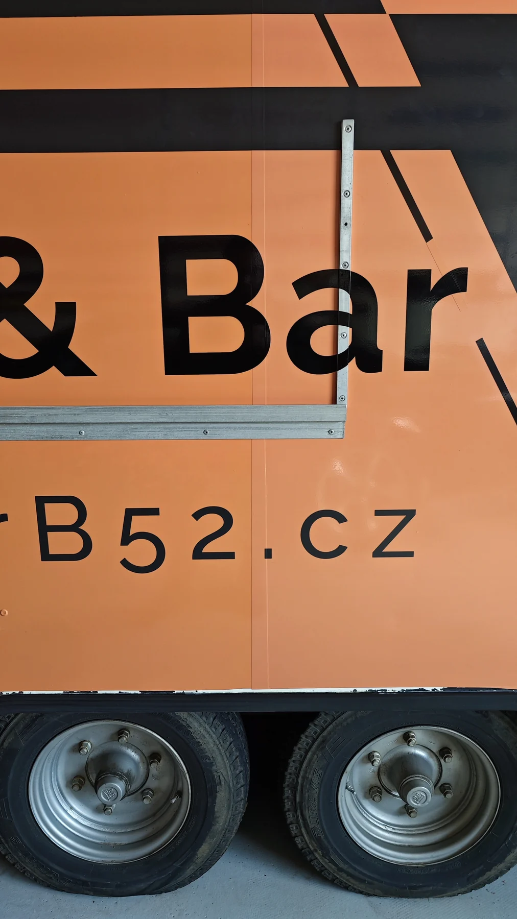 Detail nápisu a grafiky mobilního baru B52 v okolí kola