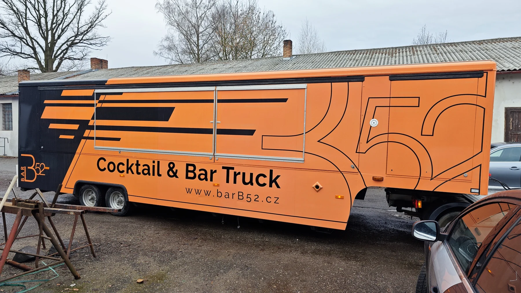 Bok mobilního baru B52 s dlouhými pruhy, obrysovým logem a textem Cocktail & Bar Truck