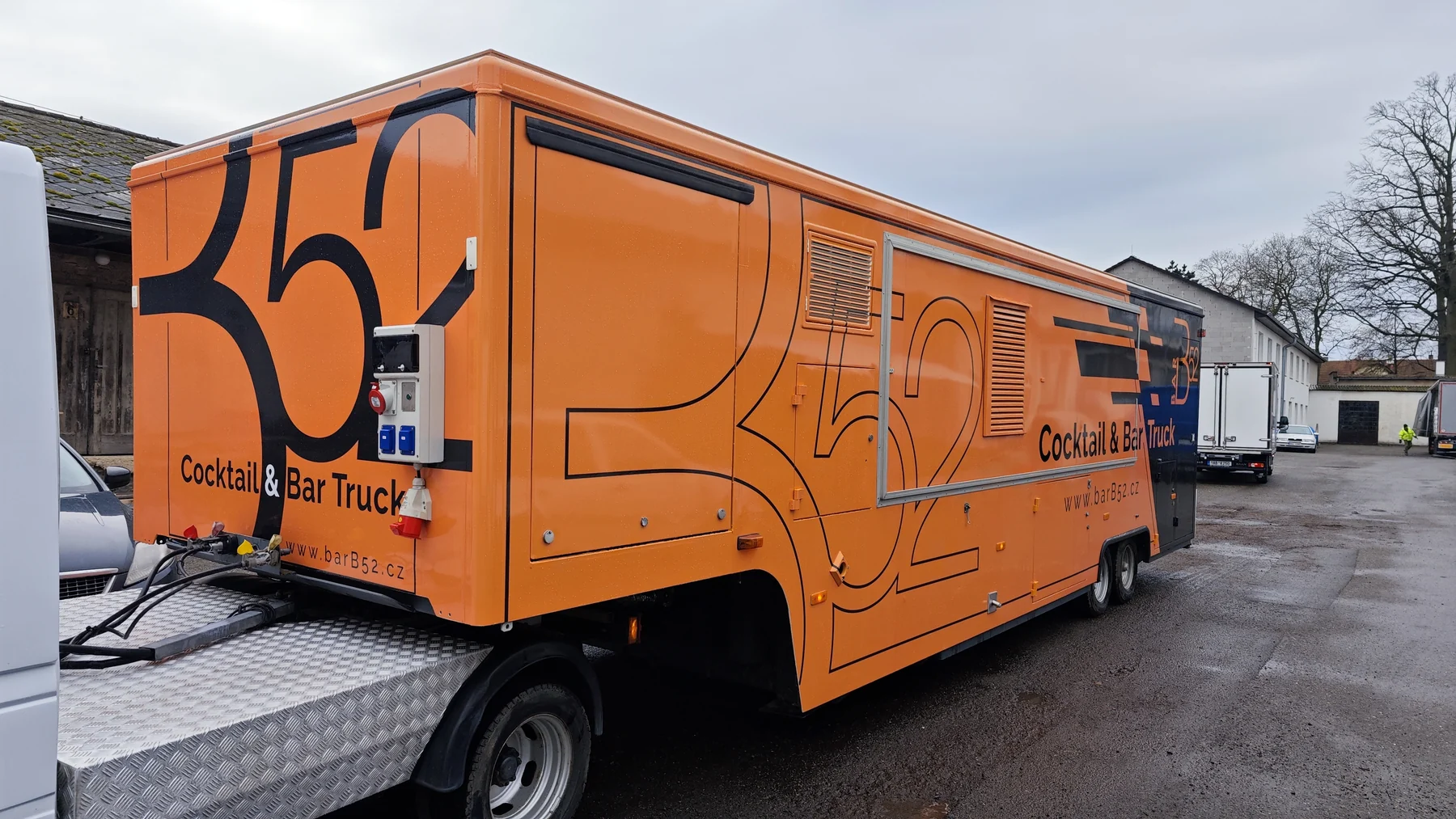 Přední část a bok oranžového mobilního baru s velkým znakem B52