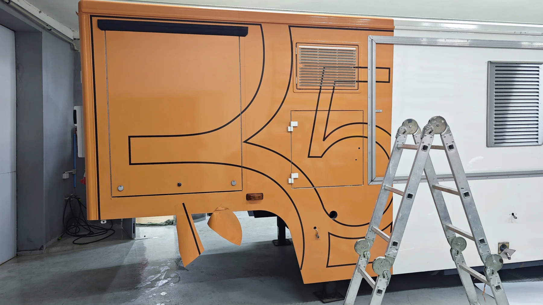 Detail rozpracované oranžové grafiky B52 kolem servisních dvířek