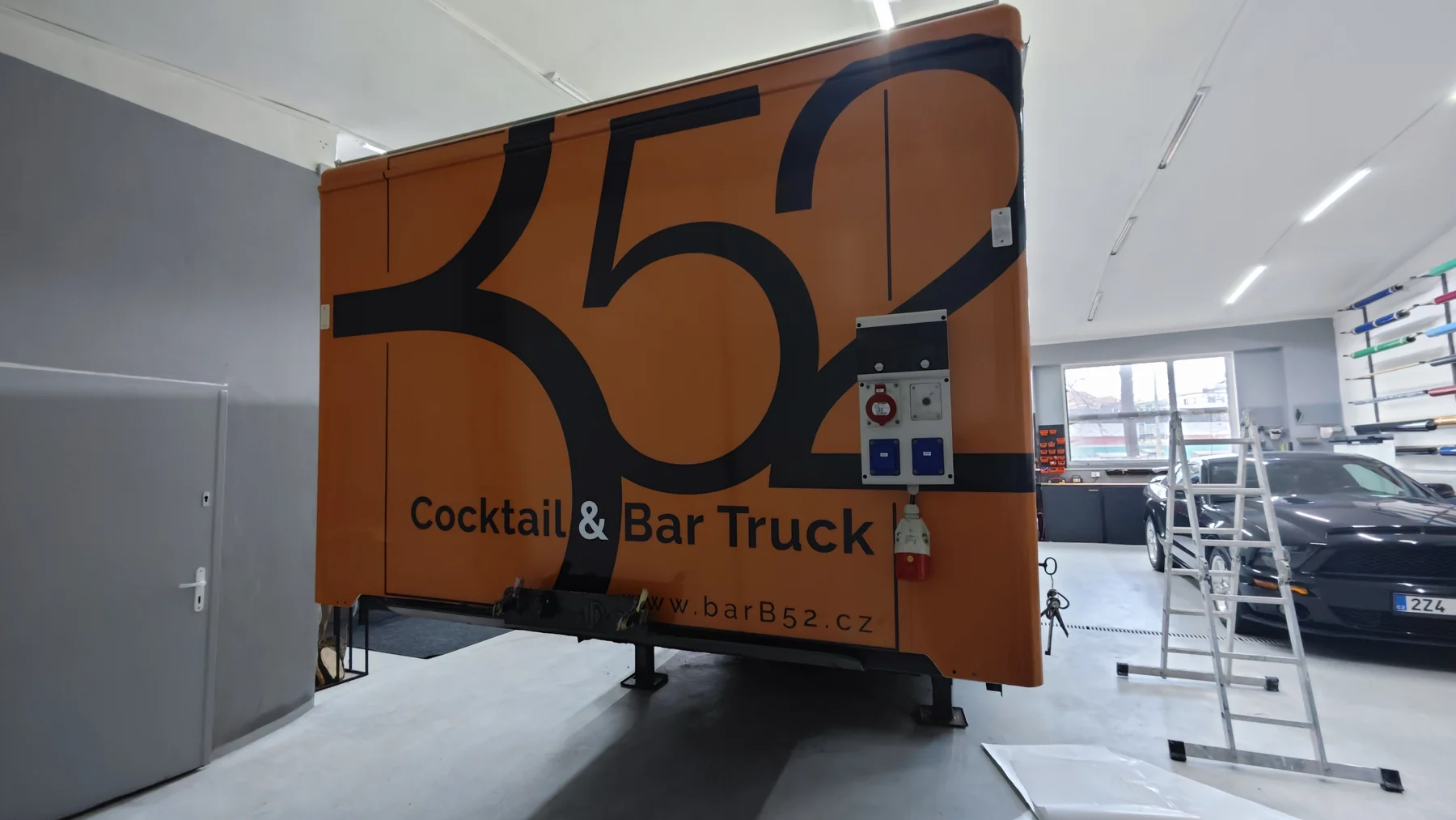 Zadní část mobilního baru B52 během práce na oranžovém polepu