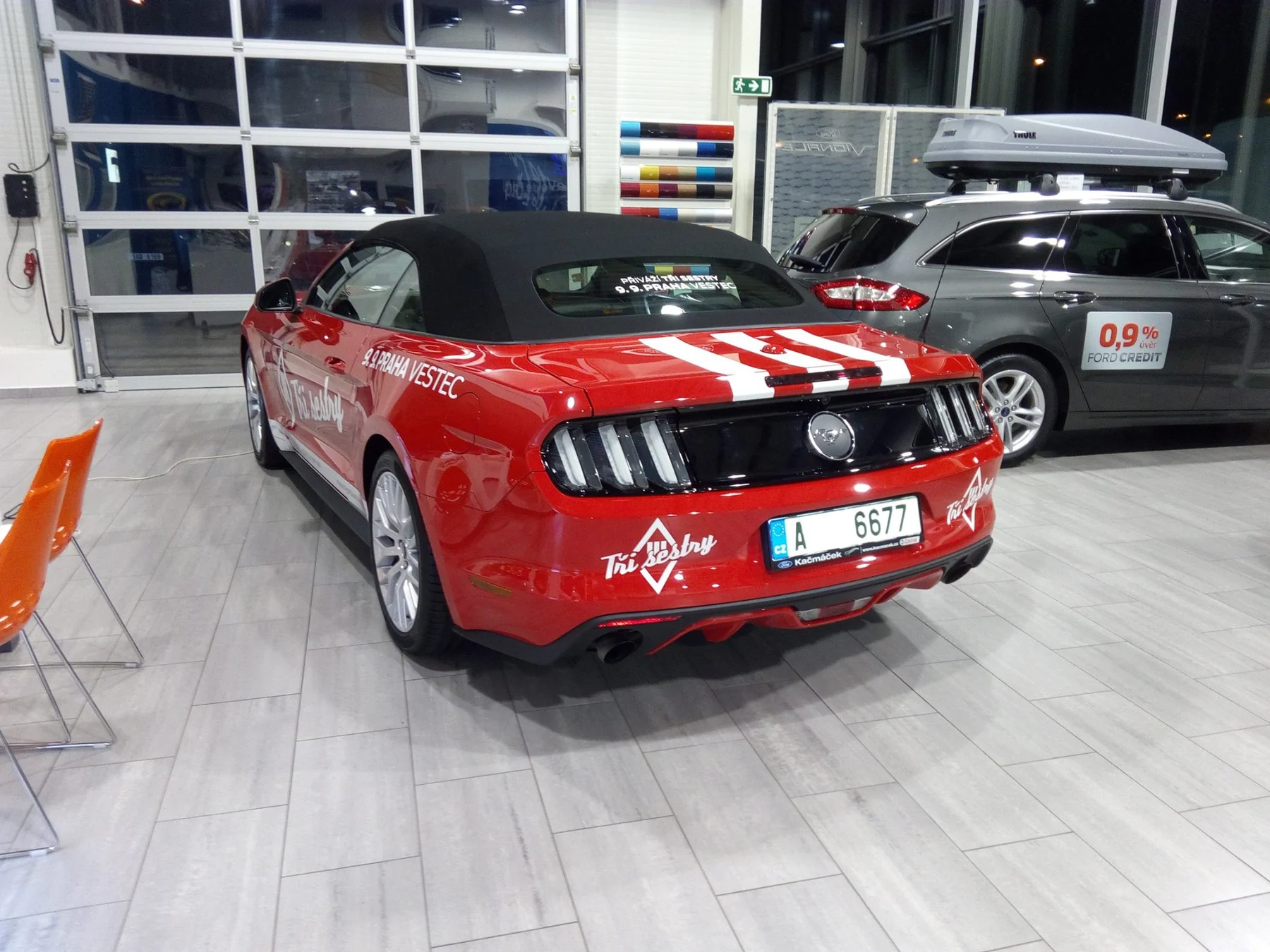 Červený Mustang zezadu s bílými pruhy a značkami na zadní části
