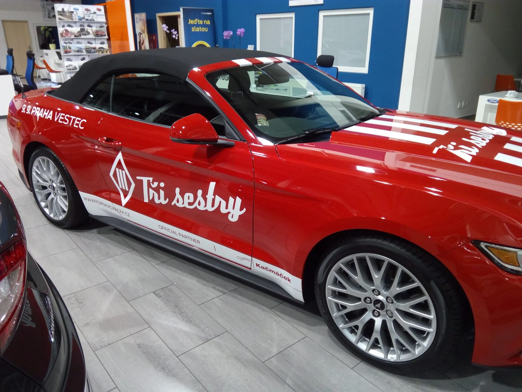 Reklamně polepený Mustang Tři sestry z druhého předního úhlu