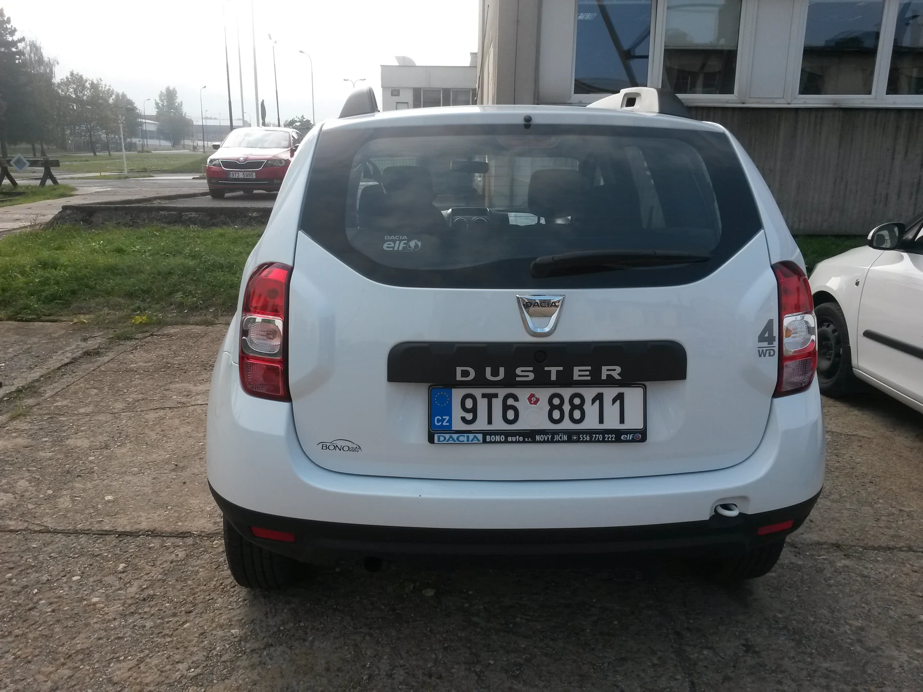 Bílá Dacia Duster před reklamním polepem Tatra Ostraha