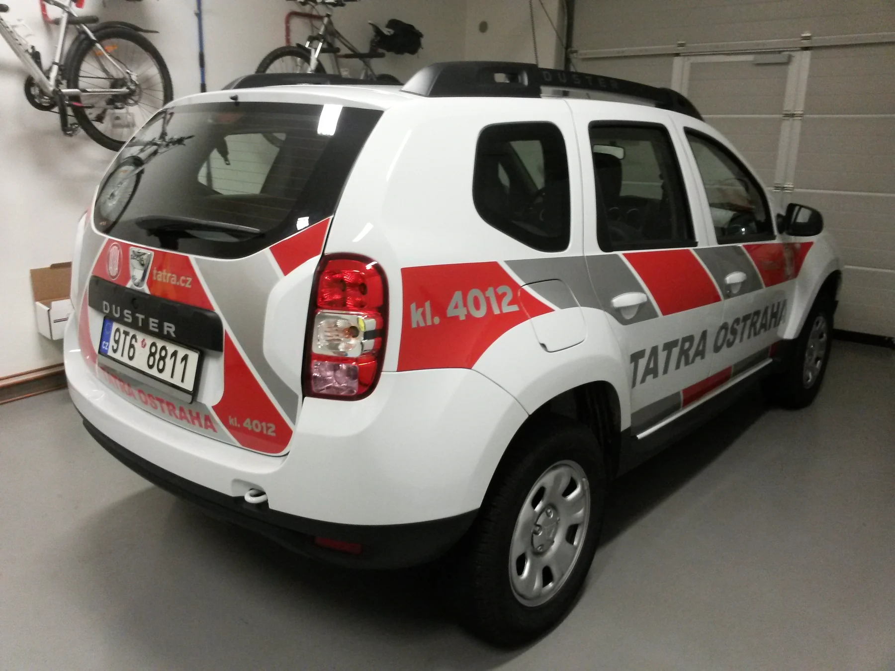 Bílá Dacia Duster Tatra Ostraha zezadu a z boku v dílně