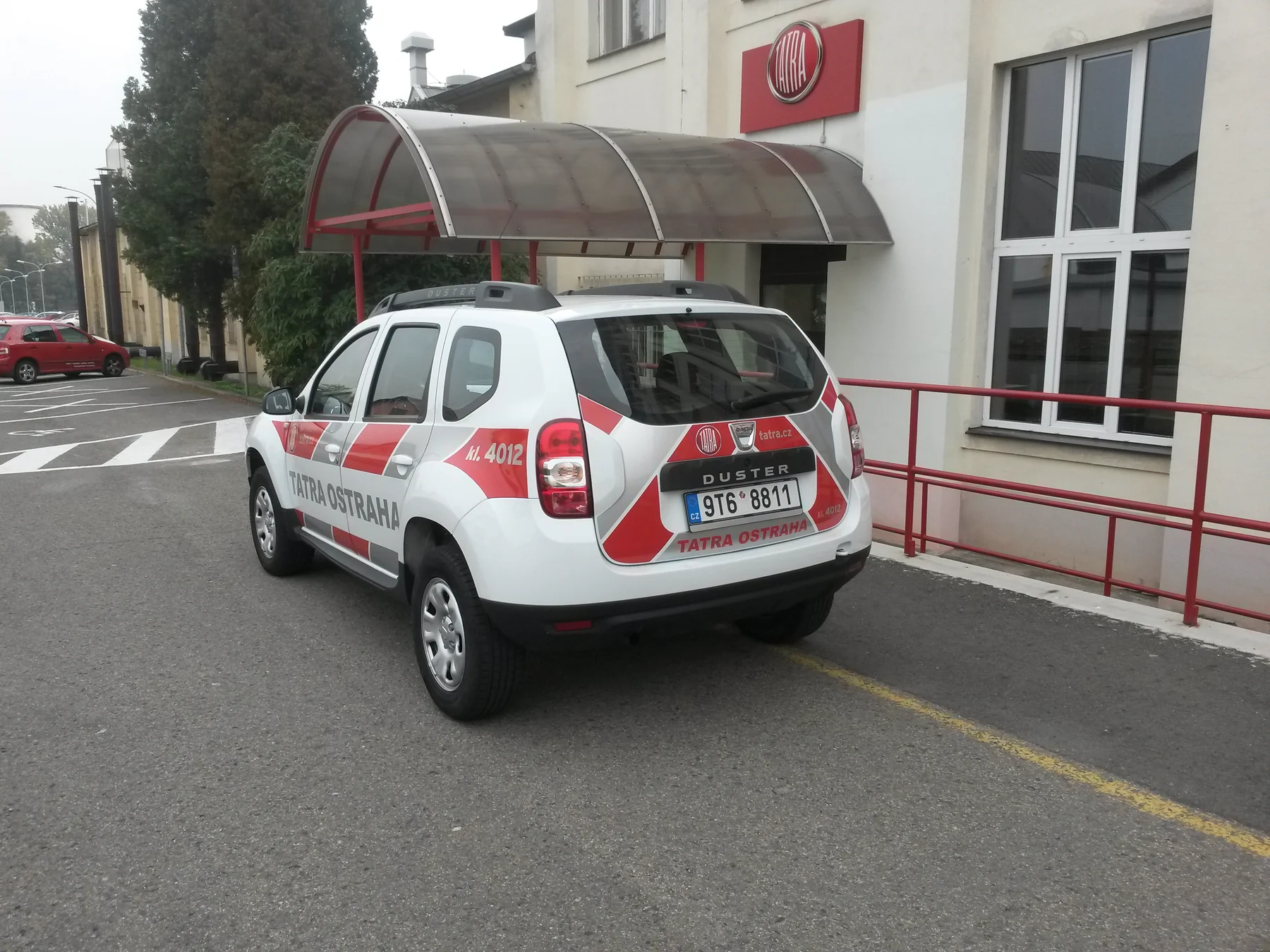 Dacia Duster s reklamním polepem Tatra Ostraha u budovy Tatra