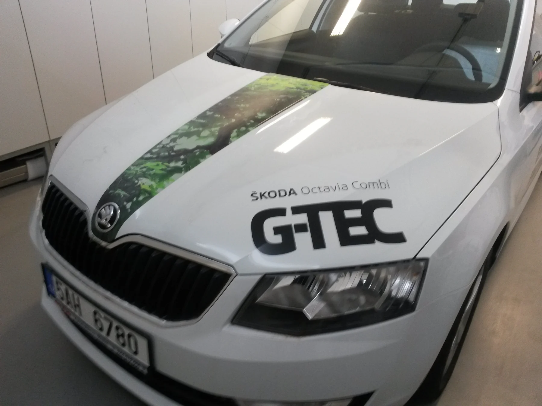 Kapota bílé Octavie G-TEC se zeleným fotografickým pruhem