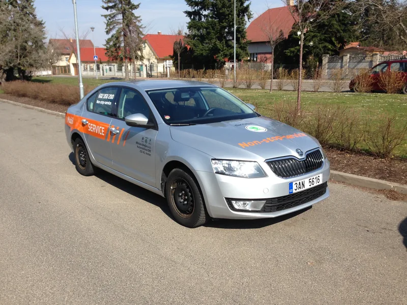 Stříbrný servisní vůz Auto Brejla s oranžovým polepem zepředu a z boku