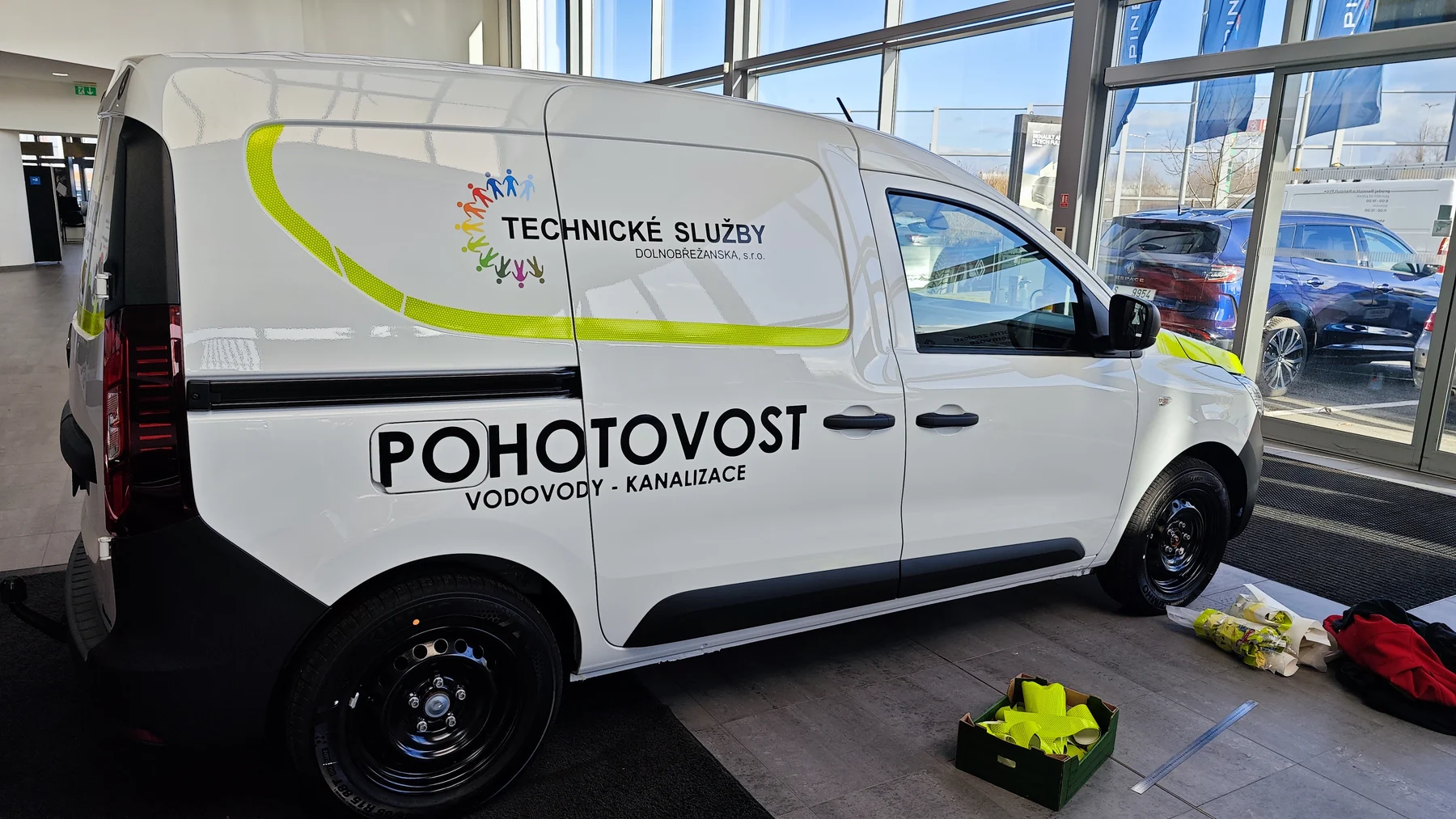 Bílý Renault technických služeb s výrazným žlutým pruhem na boku