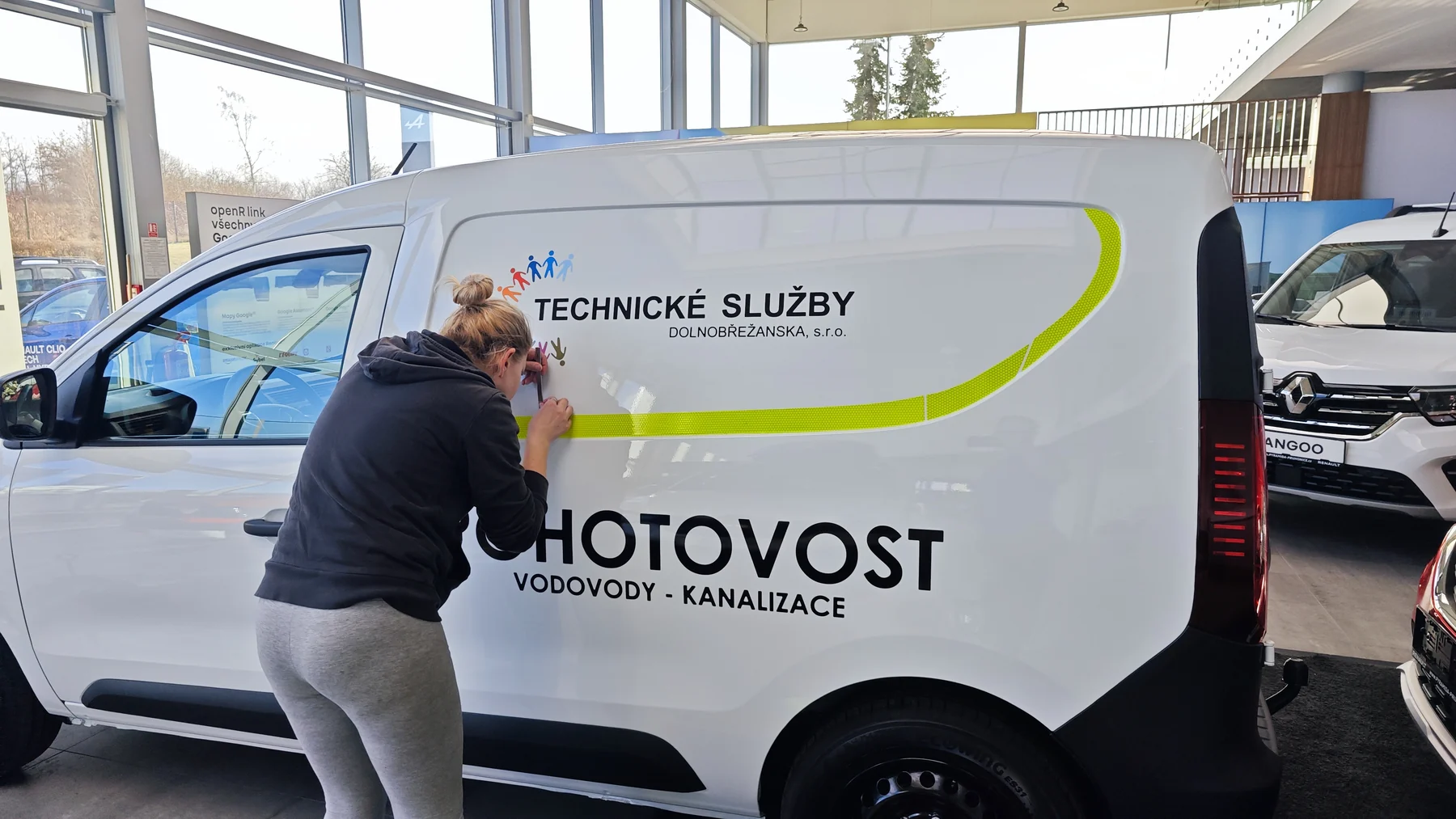 Pracovník při aplikaci bočního polepu na dodávku Renault