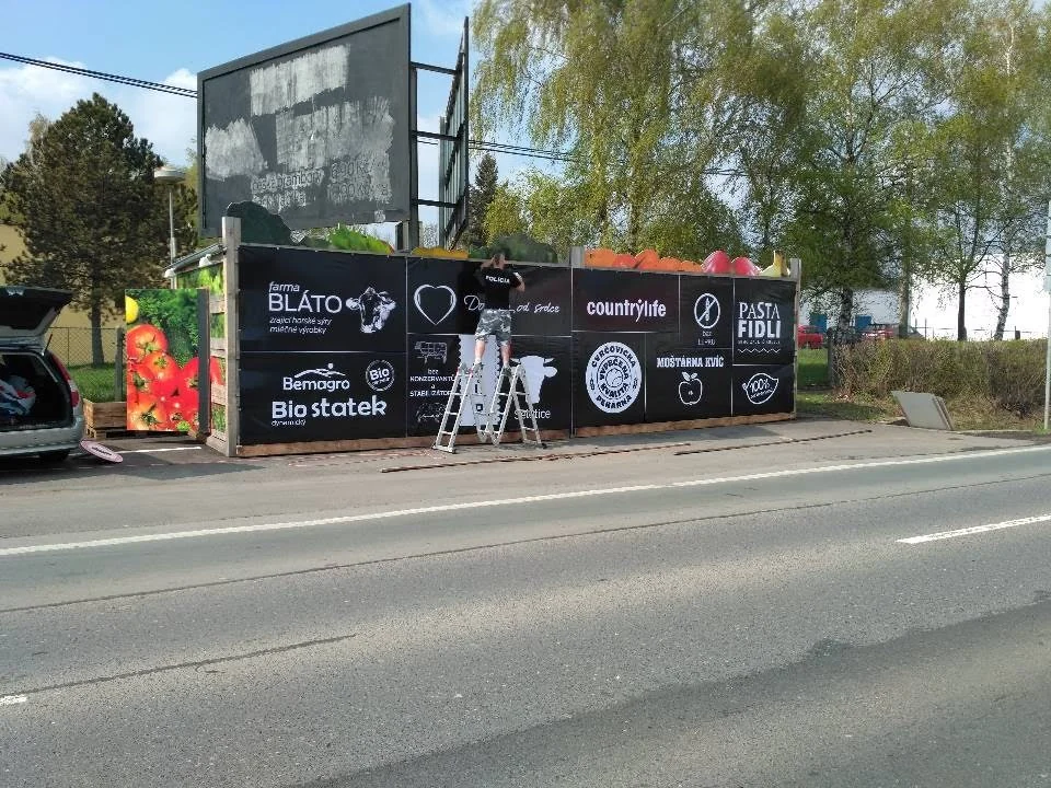 Montáž černobílé grafiky dodavatelů na čelní stěnu prodejního místa